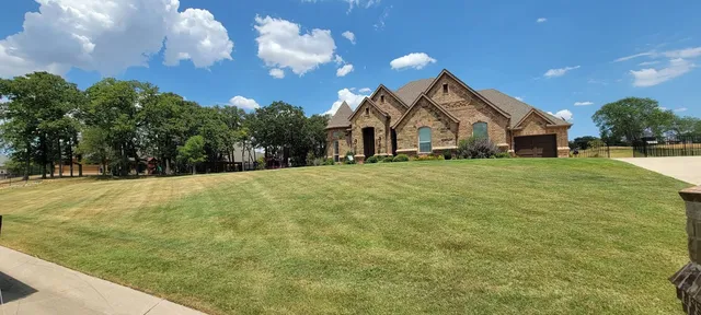 Brick home in Haslet TX with a neatly cut front lawn
